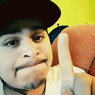 a man wearing a hat giving a thumbs up sign