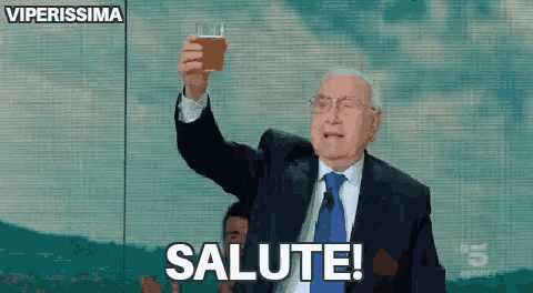 a man in a suit and tie is toasting with a glass of beer .