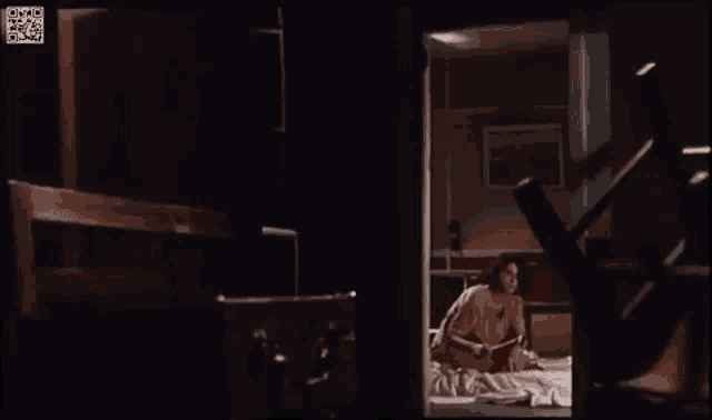 a naked woman is laying on a bed in a dark room ..