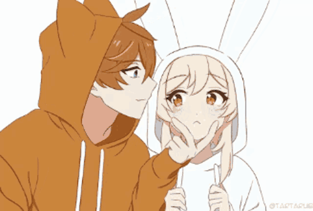 a boy in a cat hoodie kisses a girl in a bunny hoodie