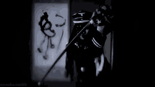 a black and white photo of a person holding a sword in a room .