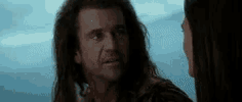 a man and a woman are looking at each other in a movie scene .