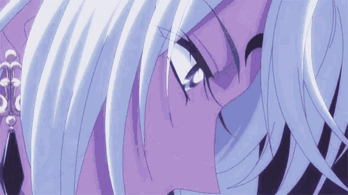 a close up of a person 's eyes with purple hair