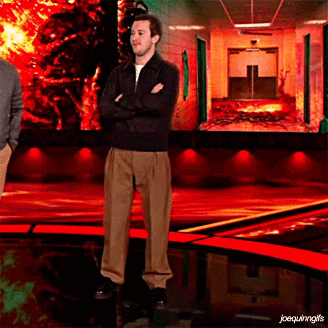 a man with his arms crossed stands in front of a screen that says joequininggifs