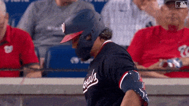 a baseball player wearing a helmet and a washington nationals jersey
