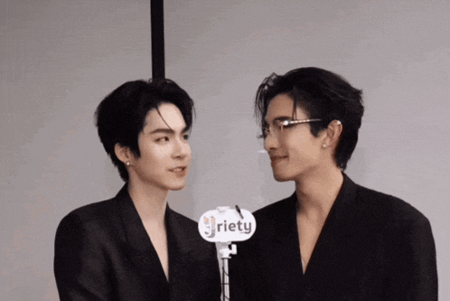 two men are standing next to each other with a sign that says riety on it