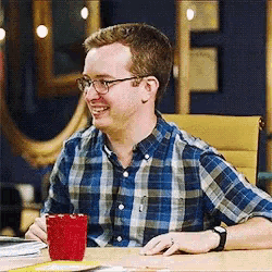 a man in a plaid shirt is sitting at a desk