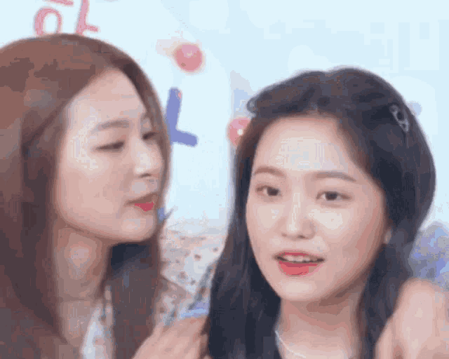 a close up of two women looking at each other with their eyes closed .