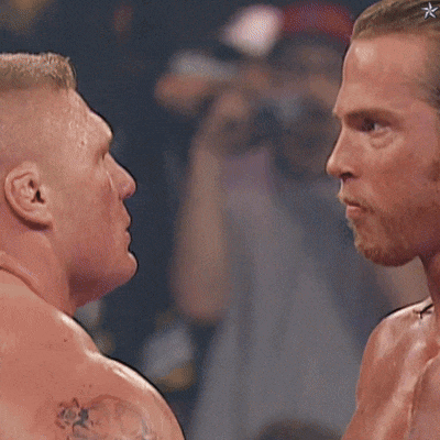 two men are looking at each other and one has a tattoo on his shoulder