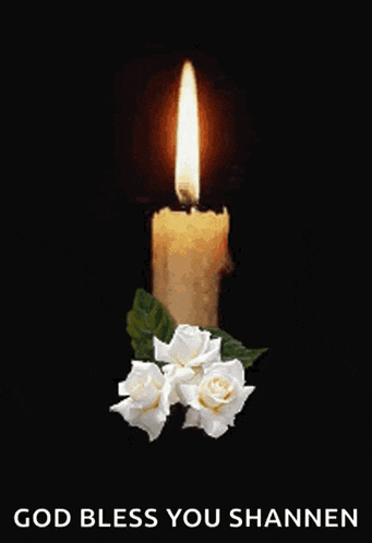 a candle with white roses and the words god bless you shannon below it