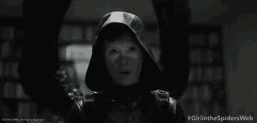 a woman in a hooded jacket is standing in a dark room with a caption that says girlinthespidersweb