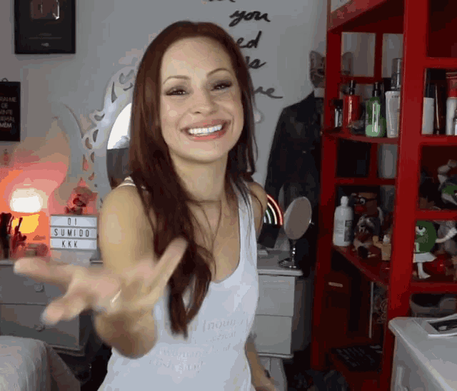 a woman wearing a white tank top that says " i 'm a dreamer "