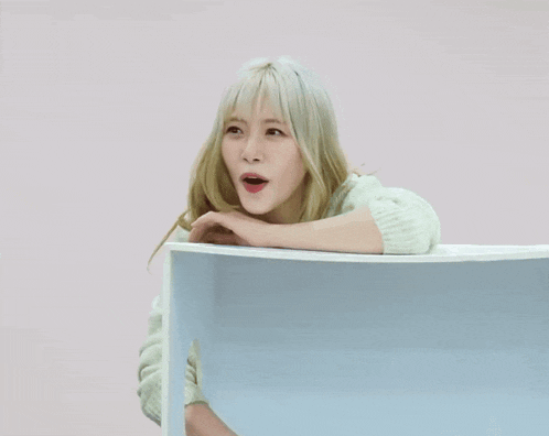 a woman with blonde hair is laughing and leaning on a chair