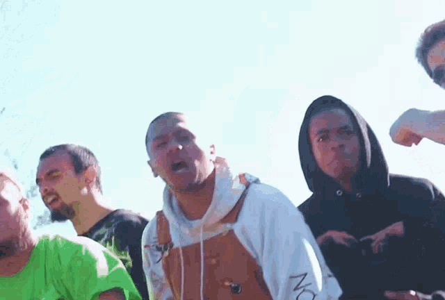 a group of men are standing next to each other and one of them is wearing a hoodie that says no