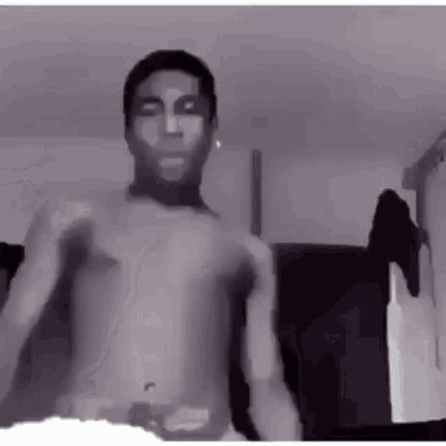 a man without a shirt is standing in a room .
