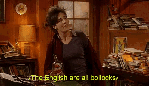 a woman holding a bottle of liquor says the english are all bollocks
