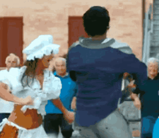 a man in a blue shirt and a woman in a white hat are dancing