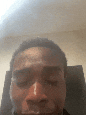 a close up of a man 's face with a tear running down his cheek