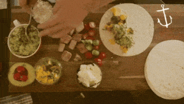 a person is preparing a tortilla with guacamole and cheese