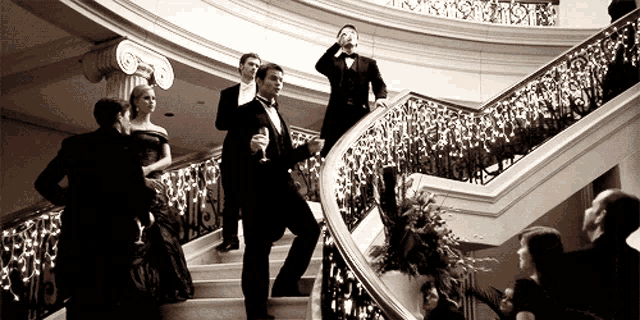 a man in a tuxedo is holding a glass of champagne