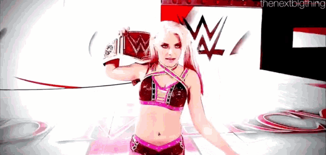 a woman in a wrestling outfit is holding a wrestling glove with a w on it