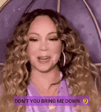 a woman with curly hair is holding a purple umbrella and says " don t you bring me down "