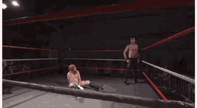 a man is wrestling another man in a wrestling ring .