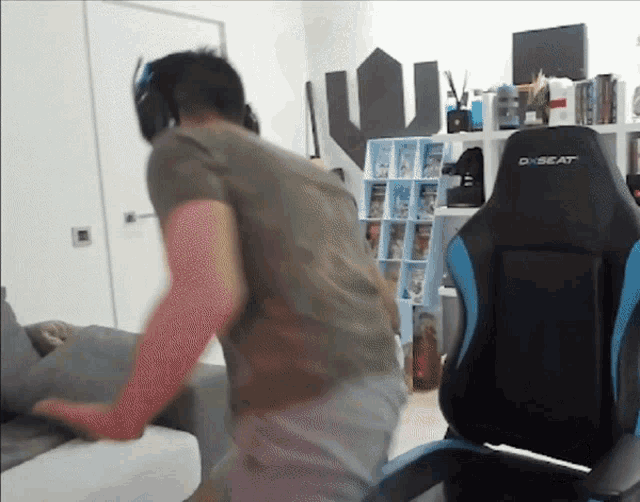 a man is standing in front of a black and blue dxbeat chair
