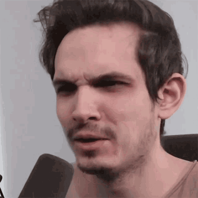 a man with a beard is making a funny face .