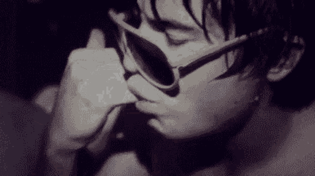 a black and white photo of a person wearing sunglasses .