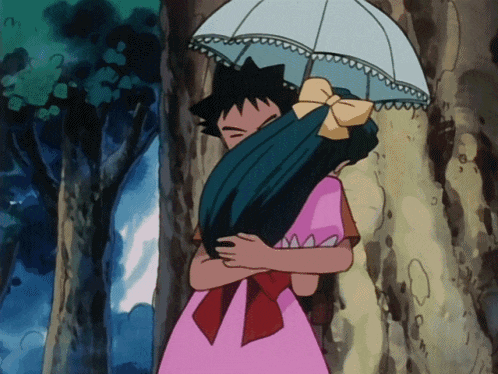 a girl in a pink dress is hugging a man under an umbrella