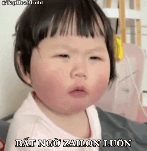 a baby is making a funny face with the words bat ngo zailon luon below it