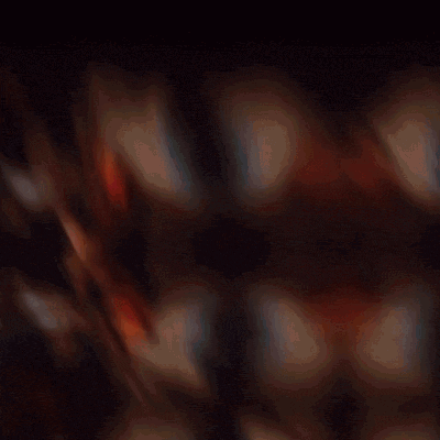 a blurred image of a man holding a gun in front of a wall