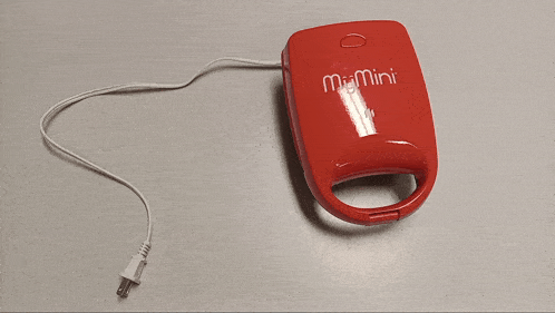 a red mr. mini waffle maker with a white cord