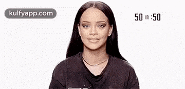 a woman is waving her hand and smiling while wearing a black t-shirt .