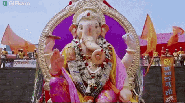 a statue of a deity with a sign that says gifkaro on the bottom