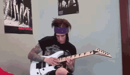 a man playing a guitar in front of a poster that says " rocket to mars "