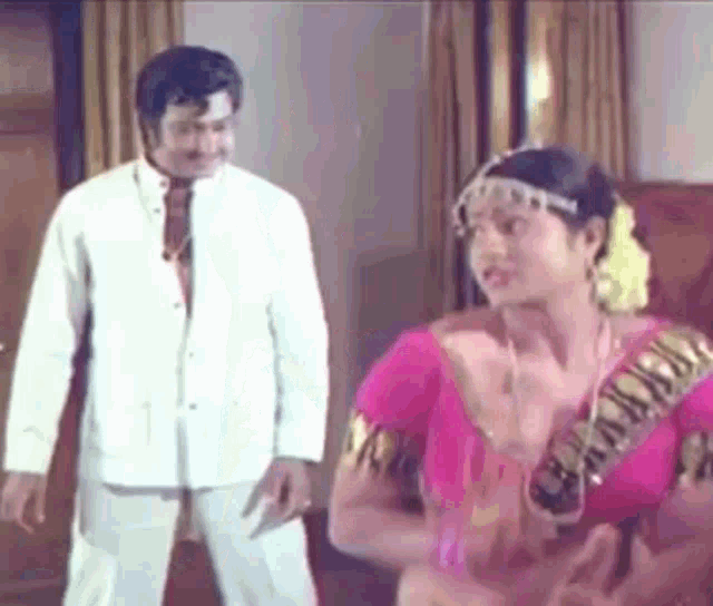 a man and woman are standing next to each other in a room .