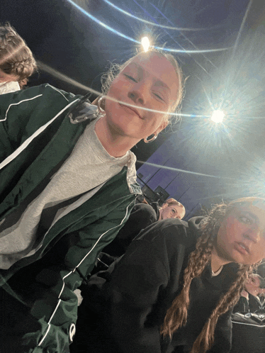 a girl wearing a green jacket with the letter p on the side