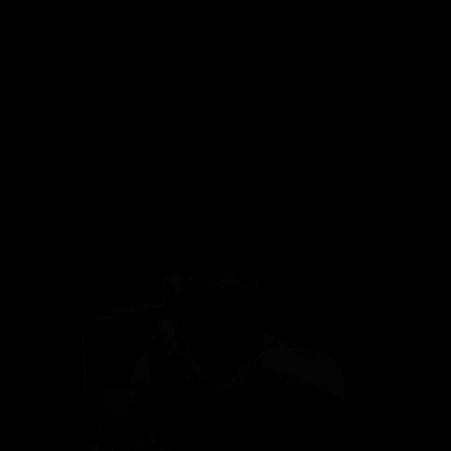 a man with a beard is looking at a cell phone in the dark