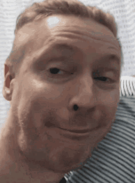 a close up of a man making a funny face with his eyes closed