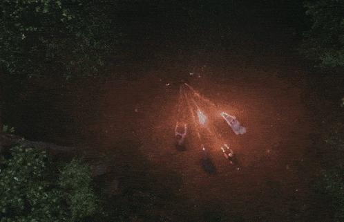a person in a dark forest with a purple glow behind them