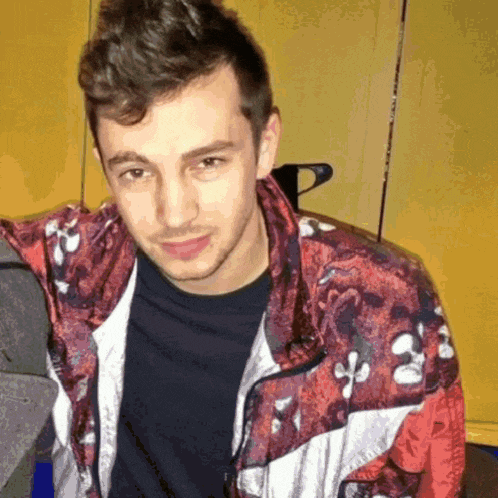 a young man wearing a red jacket with white crosses on it