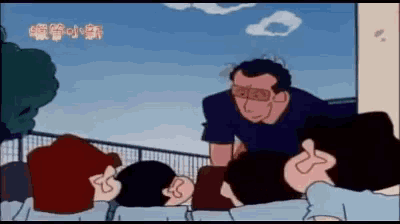 a group of people are sitting in front of a fence and a man is talking to them .