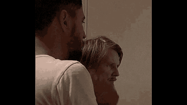 a man with a beard is standing next to another man with a beard in a room .