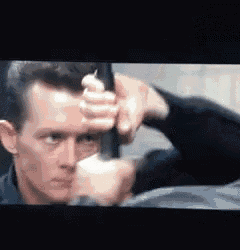a man is holding a gun in his hand in a movie scene .