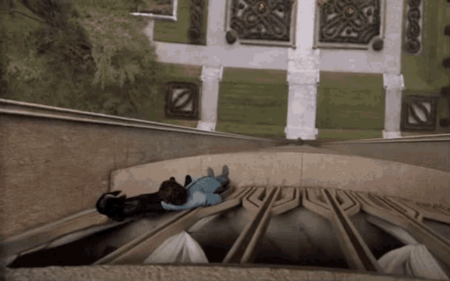 a person laying on top of a staircase with a green background