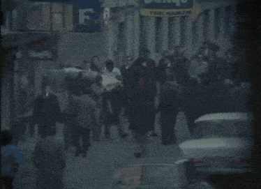 a crowd of people walking down a street in front of a banyo sign