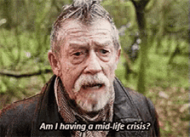 an older man with a beard and mustache is talking about having a mid-life crisis .