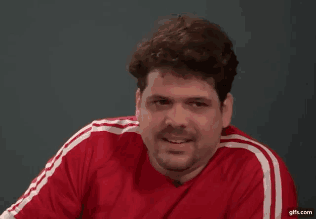 a man is wearing a red shirt with white stripes on the side
